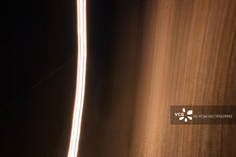 铜色背景上的抽象光曲线图片素材