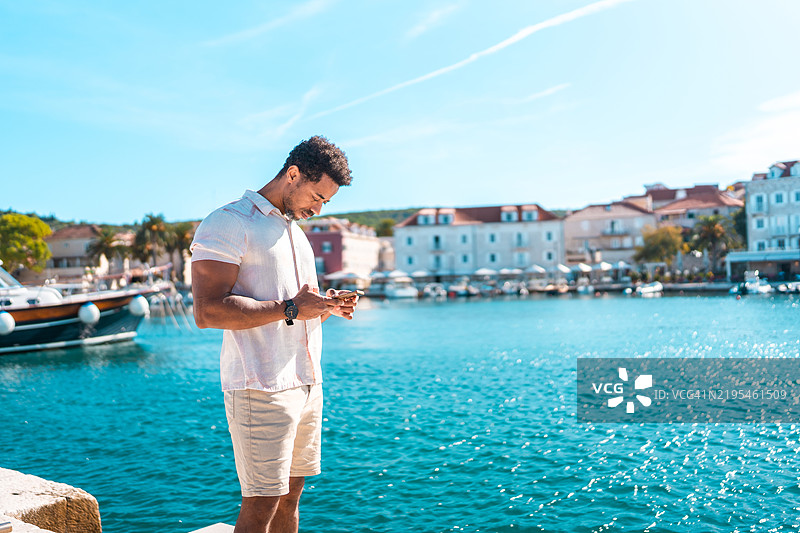 中年黑人男性在苏提万港享受使用智能手机的时光图片素材