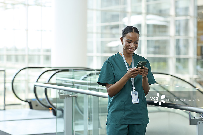 微笑的护士通过智能手机上网图片素材