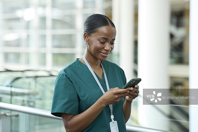 微笑的护士通过智能手机发短信图片素材