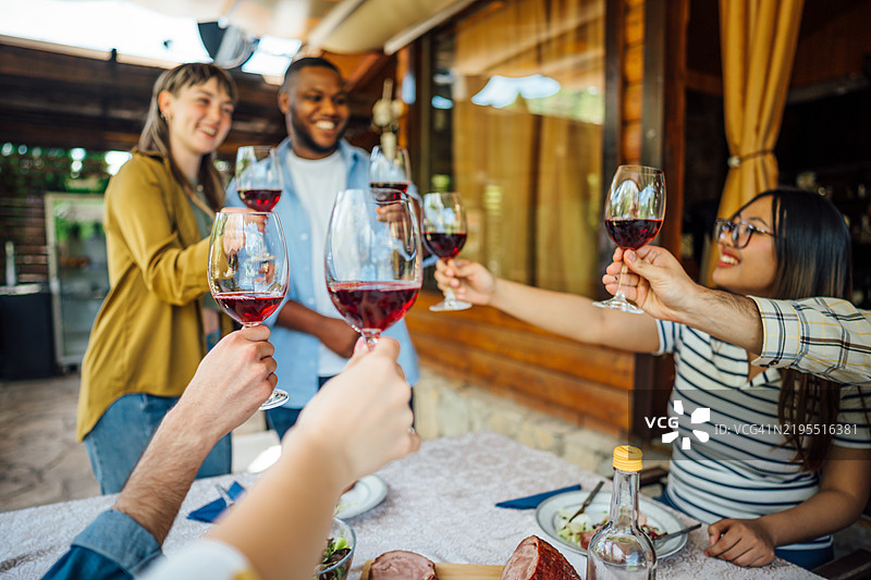 朋友们在户外午餐时举杯庆祝图片素材