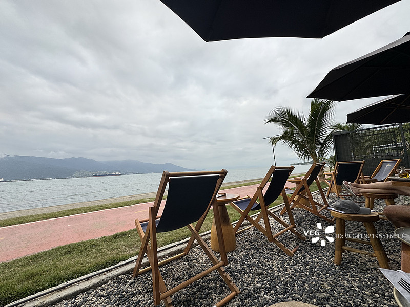 空荡荡的椅子和桌子在海滩上，背景是天空，巴西伊利哈贝拉。图片素材