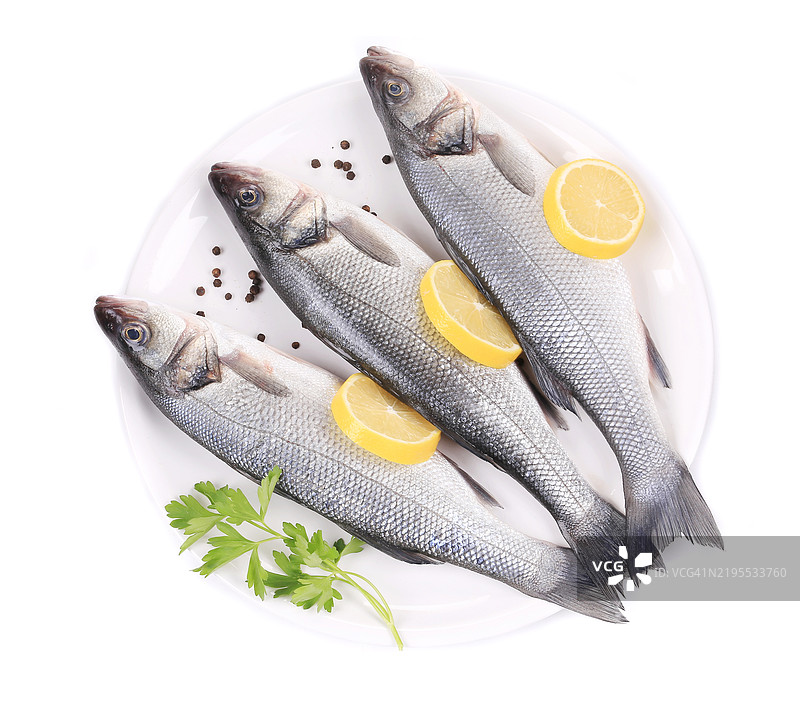 三条生鲈鱼放在盘子里图片素材