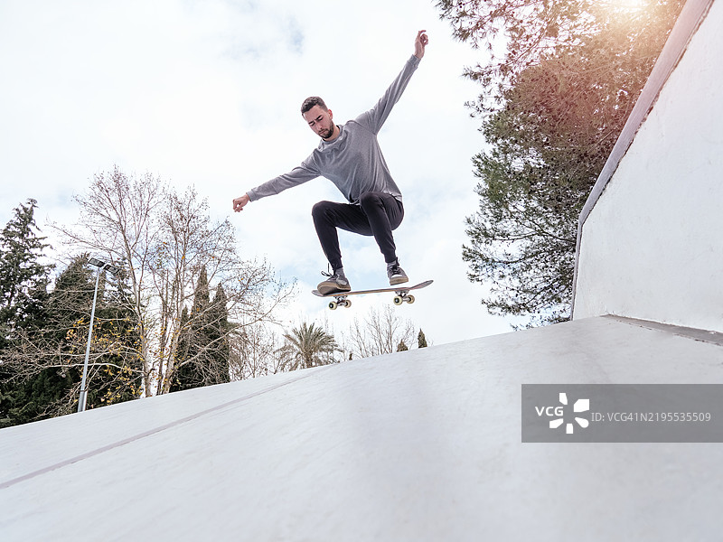 滑板运动员在滑板公园表演特技图片素材