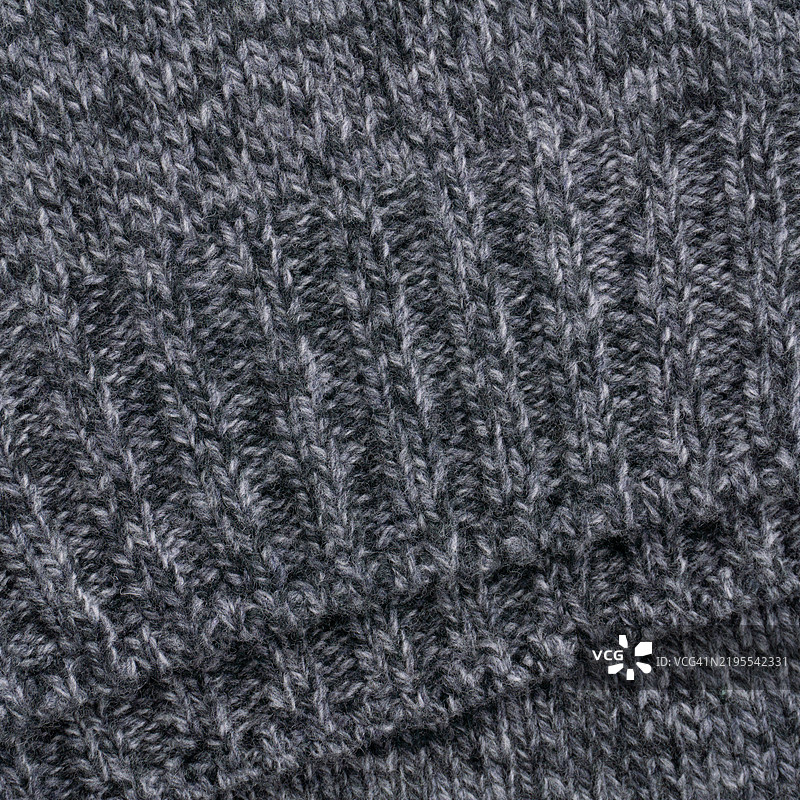 灰色混纺羊毛毛衣下摆特写，带有罗纹针织细节图片素材