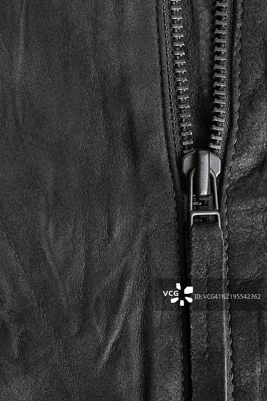 皱褶的黑色绒面垂直背景，配有黑色金属拉链图片素材