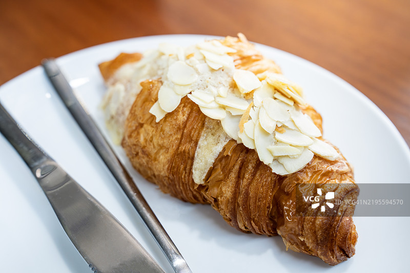 美味的杏仁可颂放在白色盘子上，随时可以享用图片素材