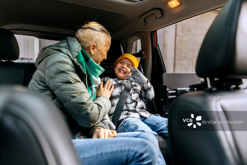 母亲和儿子在汽车后座上玩得很开心图片素材