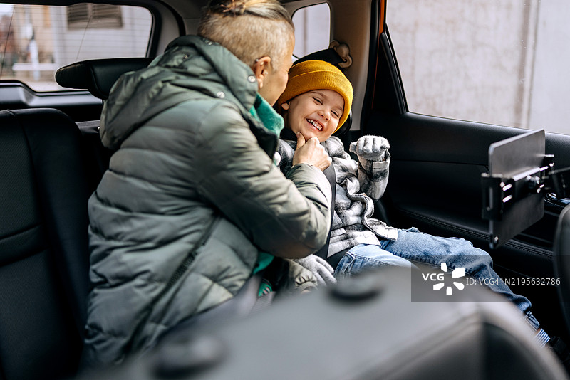 母亲和儿子在汽车后座上玩得很开心图片素材