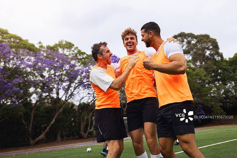 三个朋友在户外愉快地享受藤球比赛，面带笑容图片素材