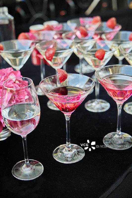 一套装满马提尼和草莓的酒杯已准备好上桌。图片素材