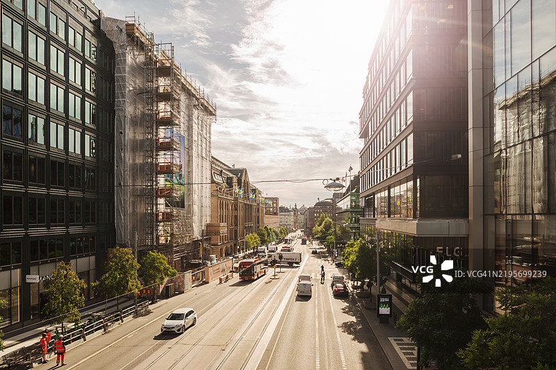 一条在逆光中的街道，位于大城市的中心。图片素材