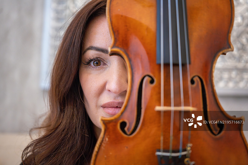 音乐家用小提琴遮住脸部图片素材