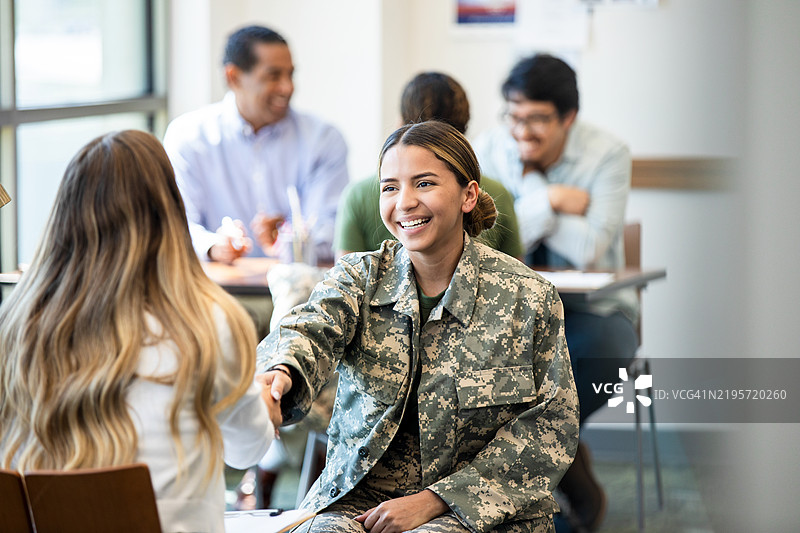 微笑的女性退伍军人在制服中握手图片素材
