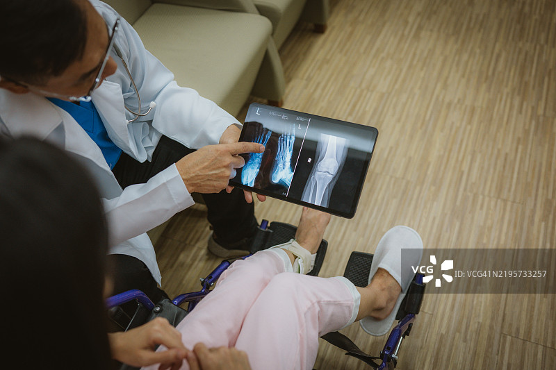 医疗咨询：医生为受伤患者解读X光片图片素材
