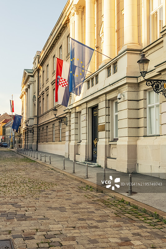 夕阳照耀着位于克罗地亚扎格雷布圣马克广场的克罗地亚议会大厦，建筑上悬挂着克罗地亚和欧盟的国旗。图片素材