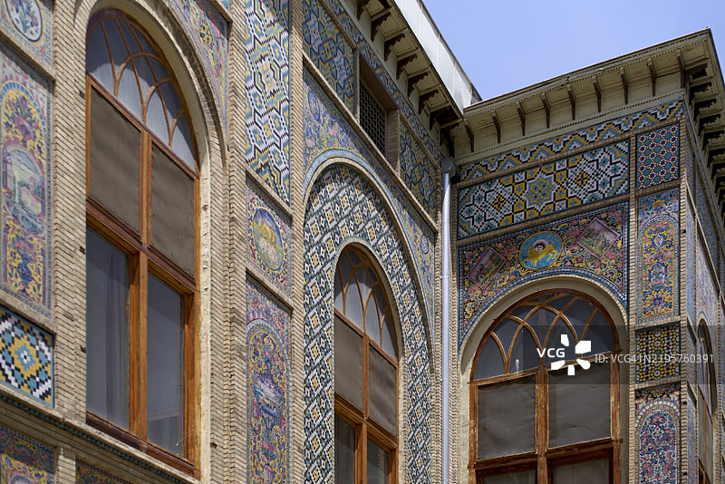 复杂的马赛克瓷砖装饰着一座历史建筑的外立面，配有拱形窗户，位于伊朗德黑兰。图片素材