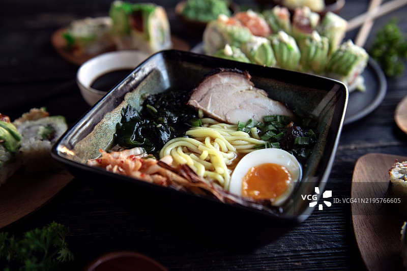 木桌上的拉面，亚洲风味的汤面，配有慢炖牛肉图片素材