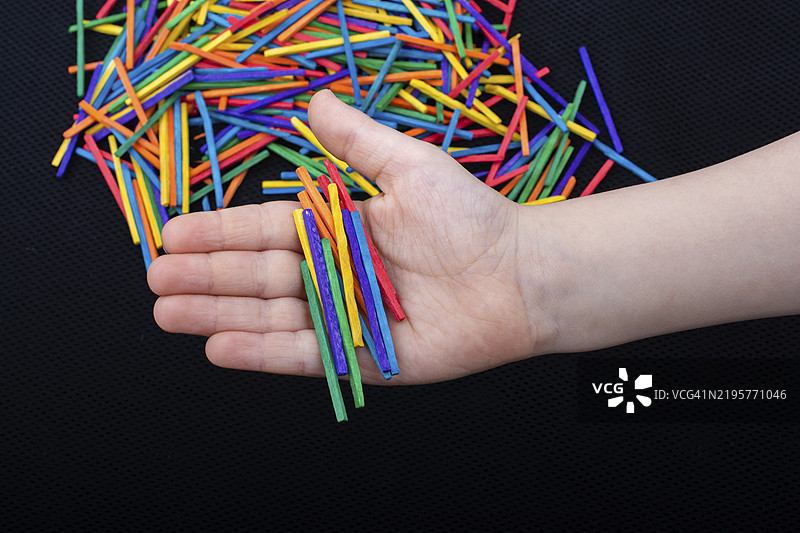 孩子在白色背景上玩彩色木棍，激发创造力图片素材