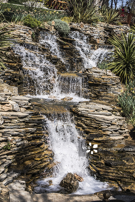 小石头瀑布倾泻入小湖中图片素材