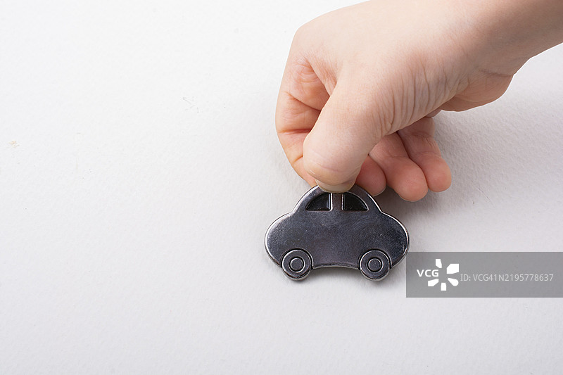 幼儿手中拿着的小汽车模型，背景为白色图片素材