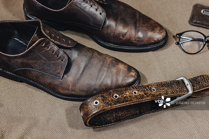 复古棕色皮鞋，搭配皮带、眼镜和钱包图片素材