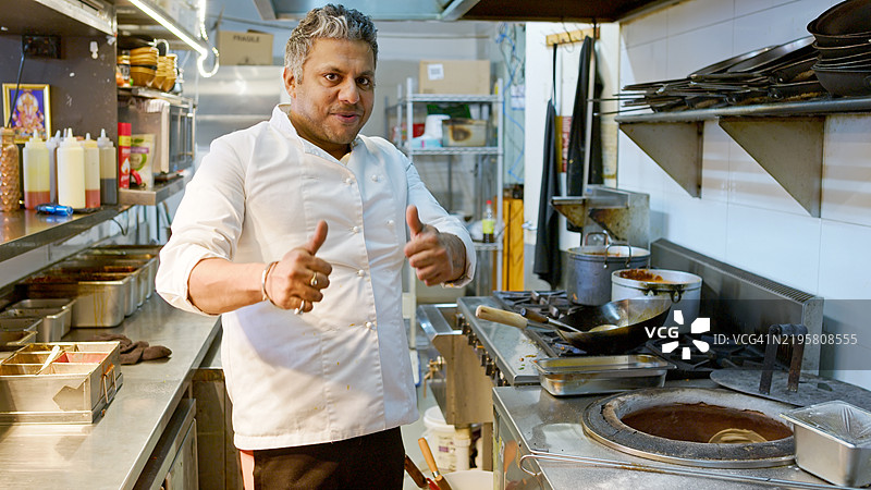 印度餐厅厨师微笑并向镜头竖起大拇指图片素材