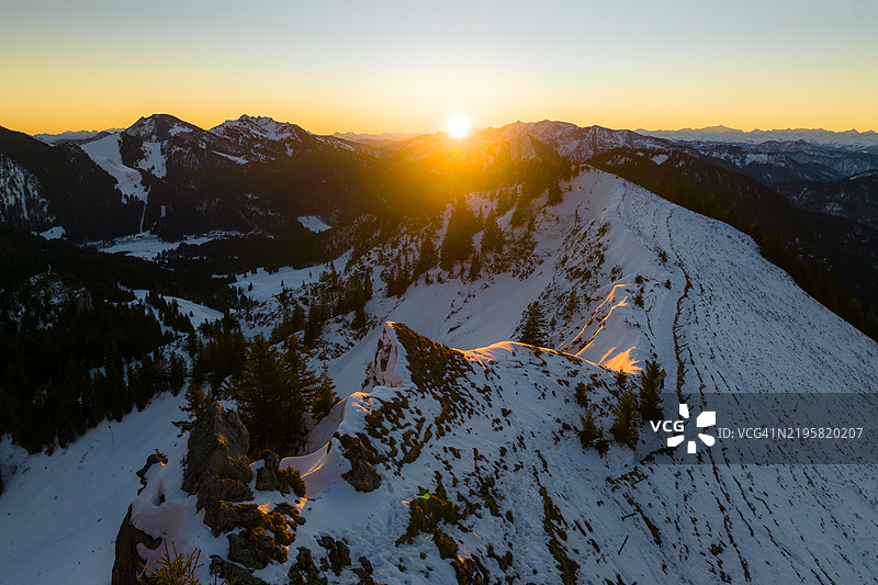 冬季山地风景的鸟瞰图，伴随着升起的太阳图片素材