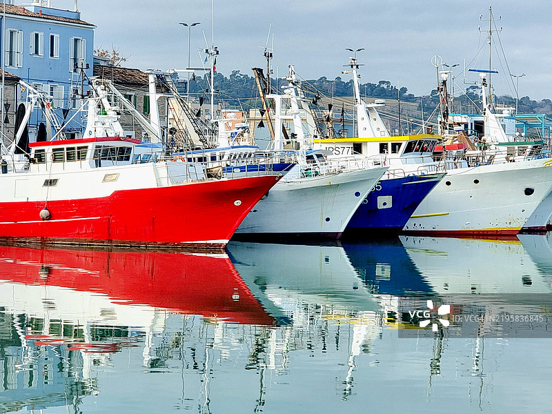 停泊的渔船在平静的水面上倒映出它们的身影，2025年1月图片素材