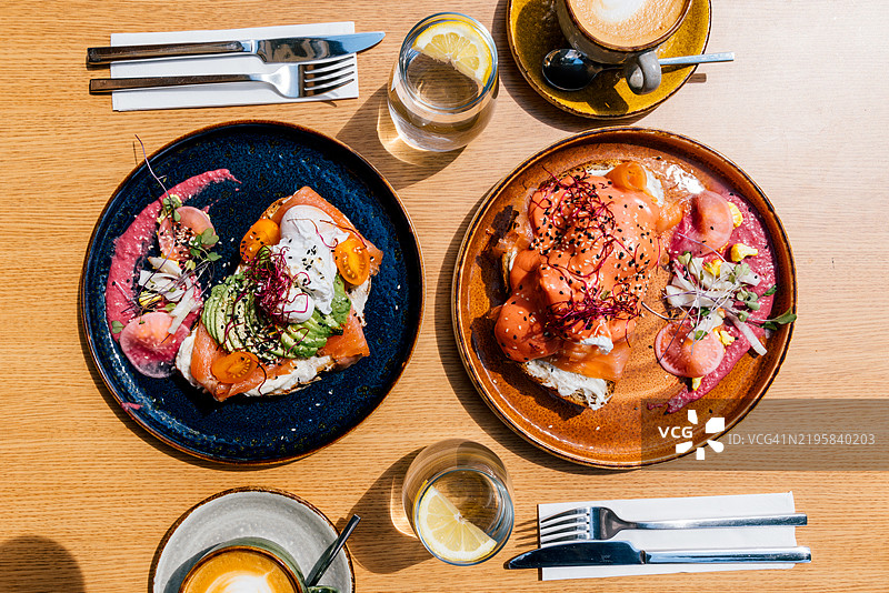 高角度视图下的餐厅早餐：烤面包配鳄梨和三文鱼图片素材