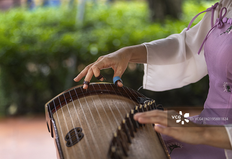 一位年轻女性在越南岘港弹奏古筝。图片素材