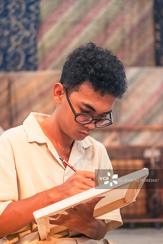 专注于创作蜡染艺术的男子图片素材