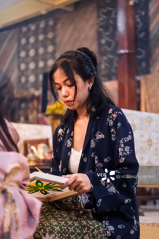 身穿传统爪哇服饰的女性参加蜡染工作坊图片素材