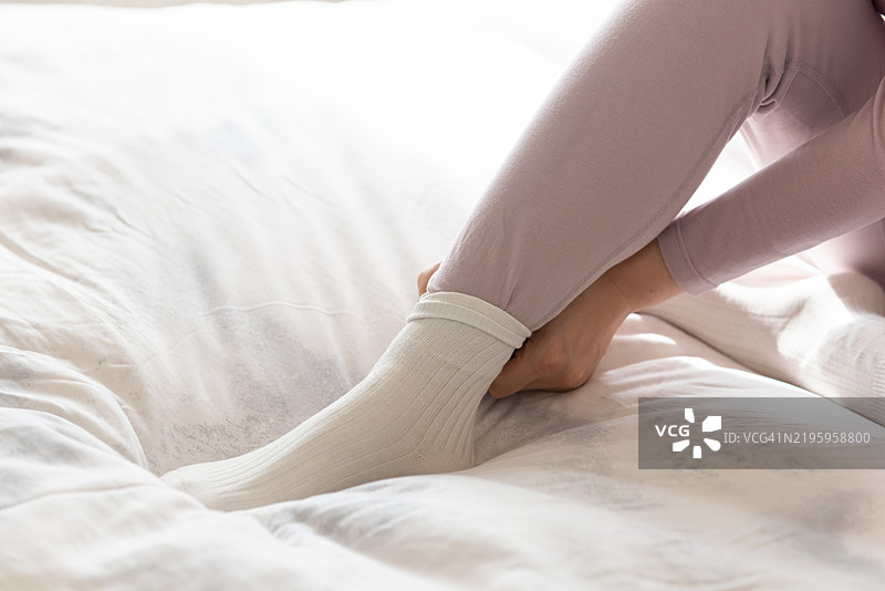 一位穿着袜子以保持温暖的女性图片素材
