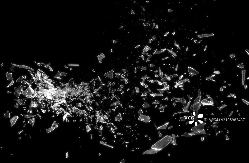 黑色背景上的破碎玻璃展示了碎玻璃的抽象纹理，细节丰富。该图像非常适合用作背景、纹理或抽象艺术项目。图片素材