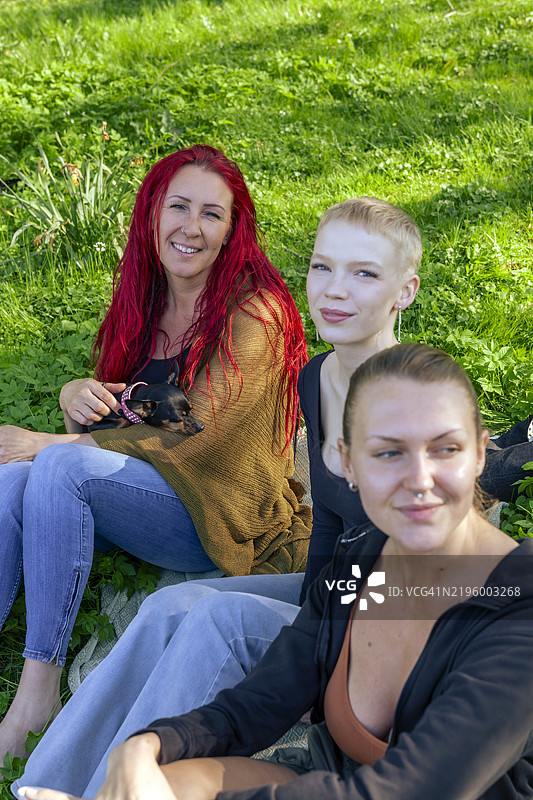 一群快乐的女性朋友坐在公园里图片素材