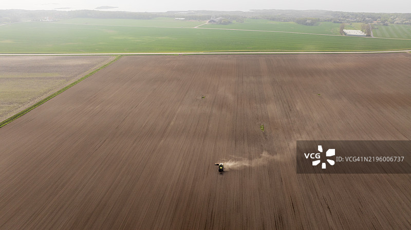 雾天农田耕作的拖拉机鸟瞰图图片素材
