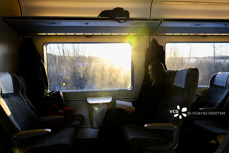 中年女性在火车上阅读书籍图片素材