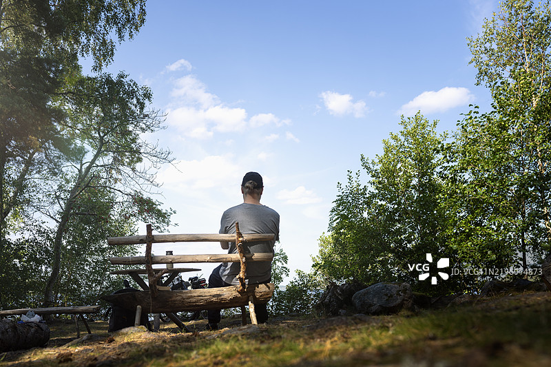 森林中坐在木凳上的男人背影图片素材