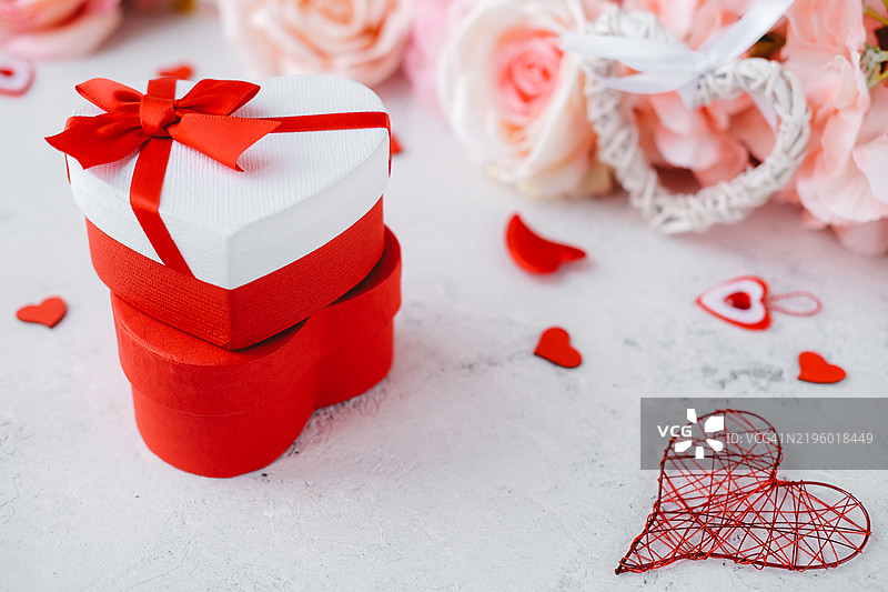 心形礼品盒，情人节元素和浅粉色花朵。图片素材