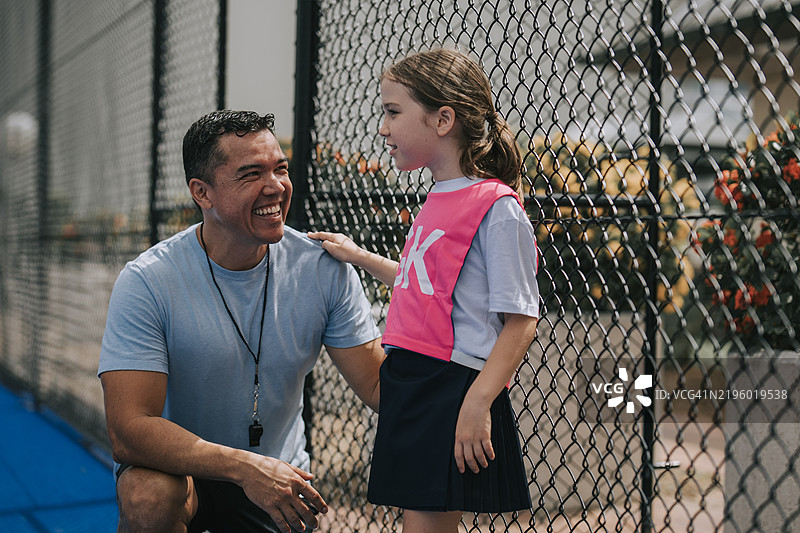 澳大利亚教练与女儿建立亲密关系，年轻的网球队守门员在训练中。图片素材