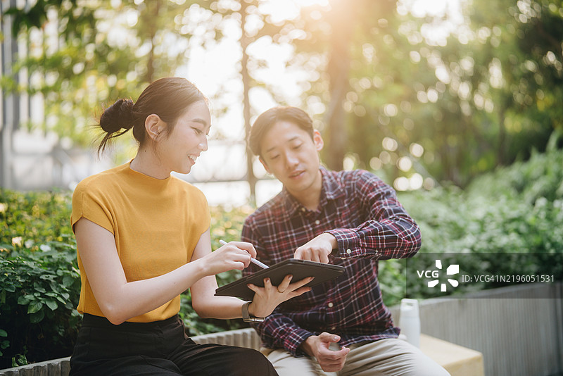 两名亚洲专业勘测团队正在走向现场，进行太阳能电池板安装的勘测。图片素材