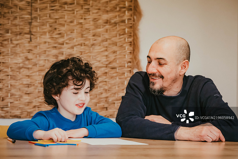 一个小男孩正在和他的爸爸学习数学图片素材