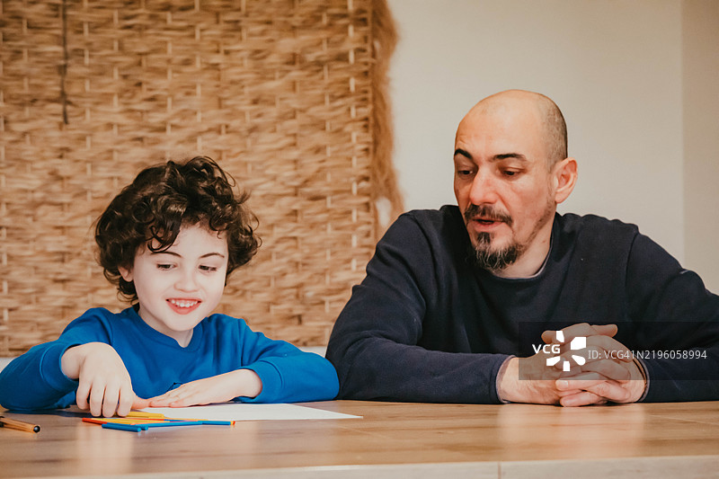 一个小男孩正在和他的爸爸学习数学图片素材
