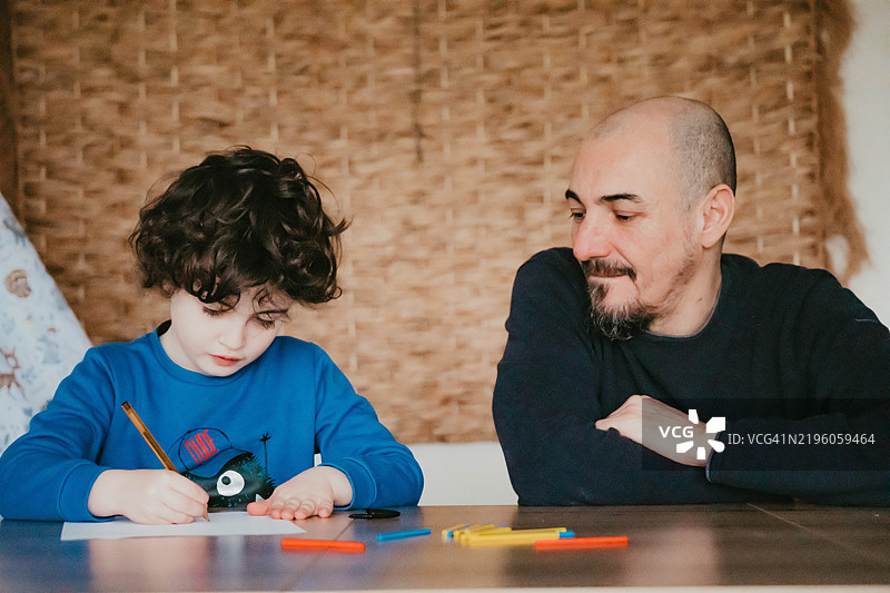 一个小男孩正在和他的爸爸学习数学图片素材