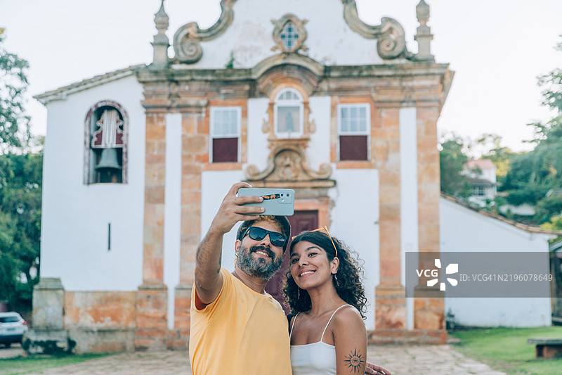 一对情侣在米纳斯吉拉斯州的提拉登特斯教堂前自拍图片素材