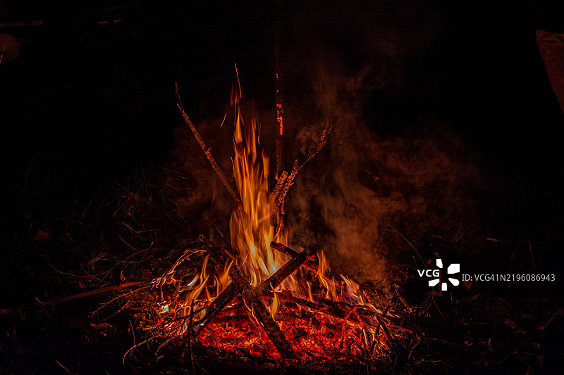篝火在黑暗中熊熊燃烧，火星和火焰四溅图片素材