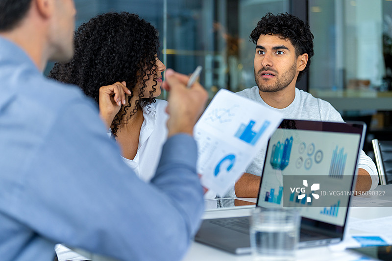 一对情侣在听一位使用笔记本电脑的商人、银行家、医生或财务顾问的讲解图片素材