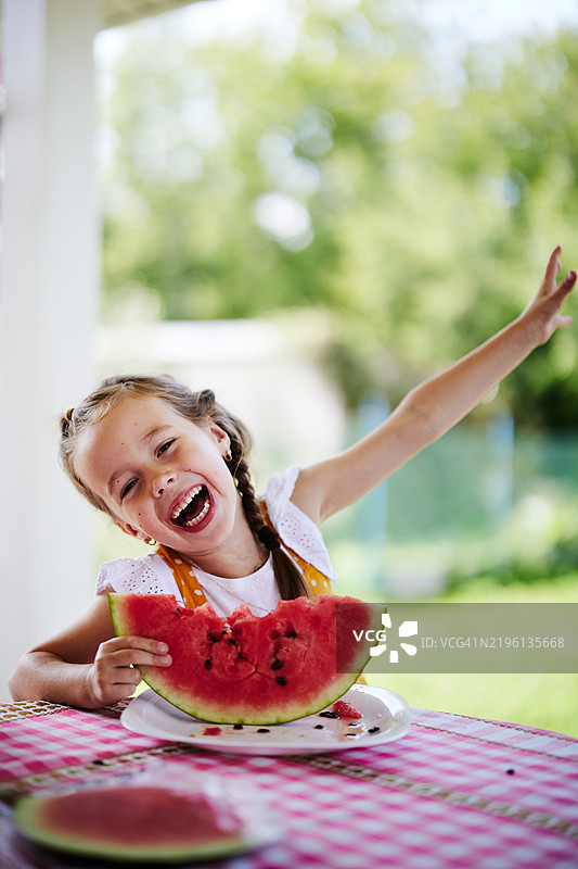 快乐的孩子在夏天户外享受多汁的西瓜片图片素材