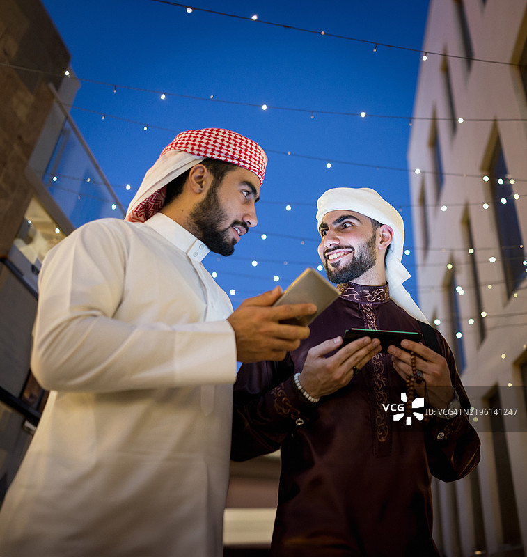 两个阿拉伯年轻人在夜晚的城市街道上图片素材